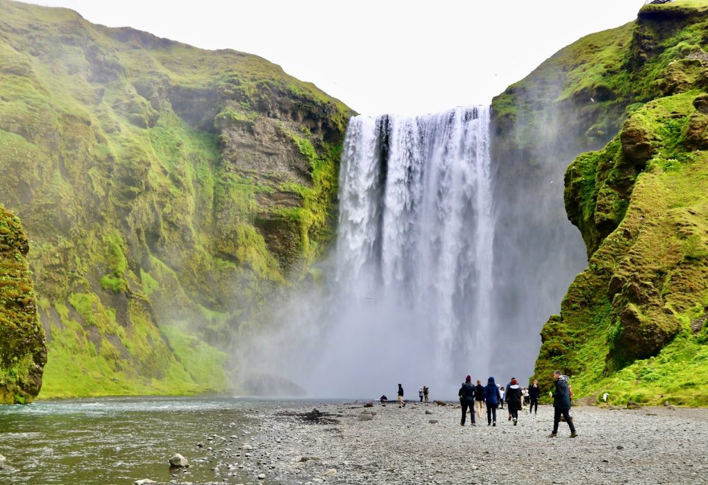 a group of people standing in front of a waterfall