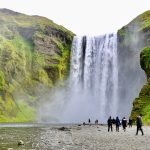 a group of people standing in front of a waterfall