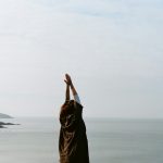 woman in brown hijab covering her face with her hand