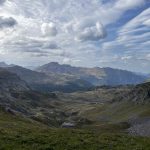 A view of the mountains from a grassy hill