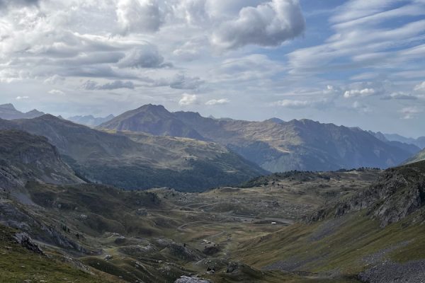 A view of the mountains from a grassy hill