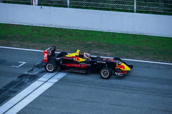 a red and yellow race car driving down a race track