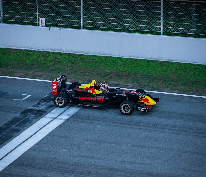 a red and yellow race car driving down a race track