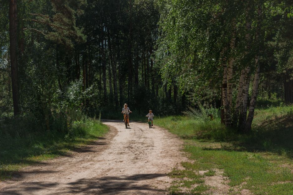 Niño montando en bicicleta por un camping en verano