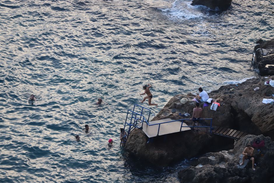 Grupo haciendo coasteering saltando desde rocas junto al mar