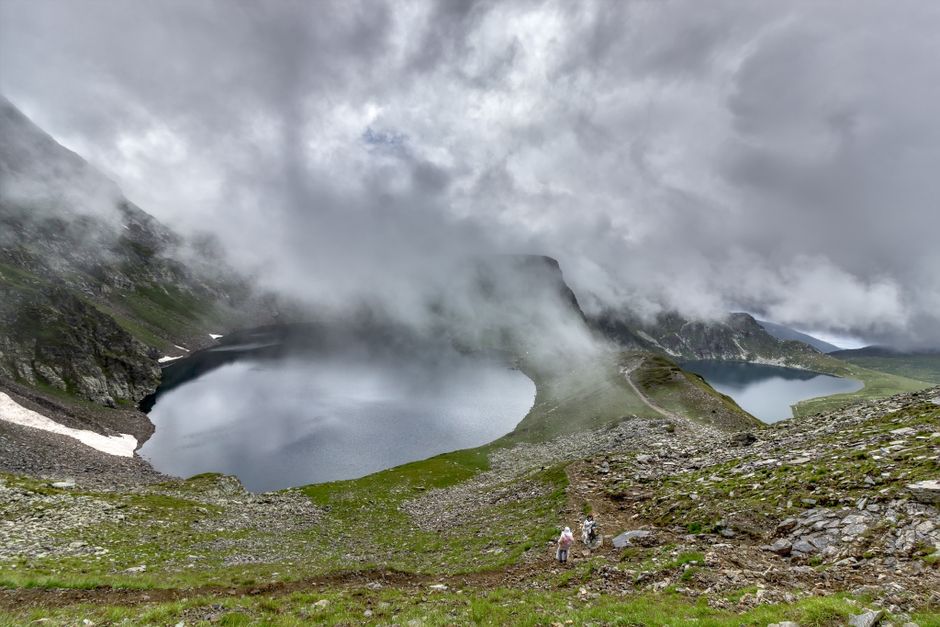 Senderistas junto a un lago de alta montaña en la Sierra de Gredos