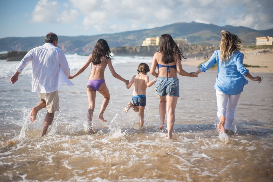 Familia disfrutando de un día de playa en verano con niños