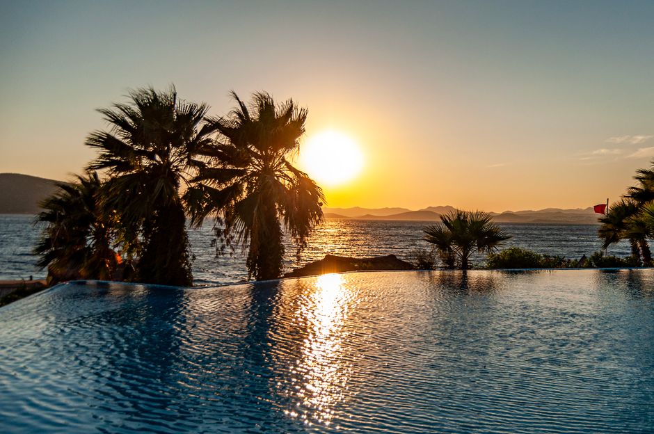 Piscina infinita de un hotel de diseño en Ibiza con vistas al mar Mediterráneo al atardecer