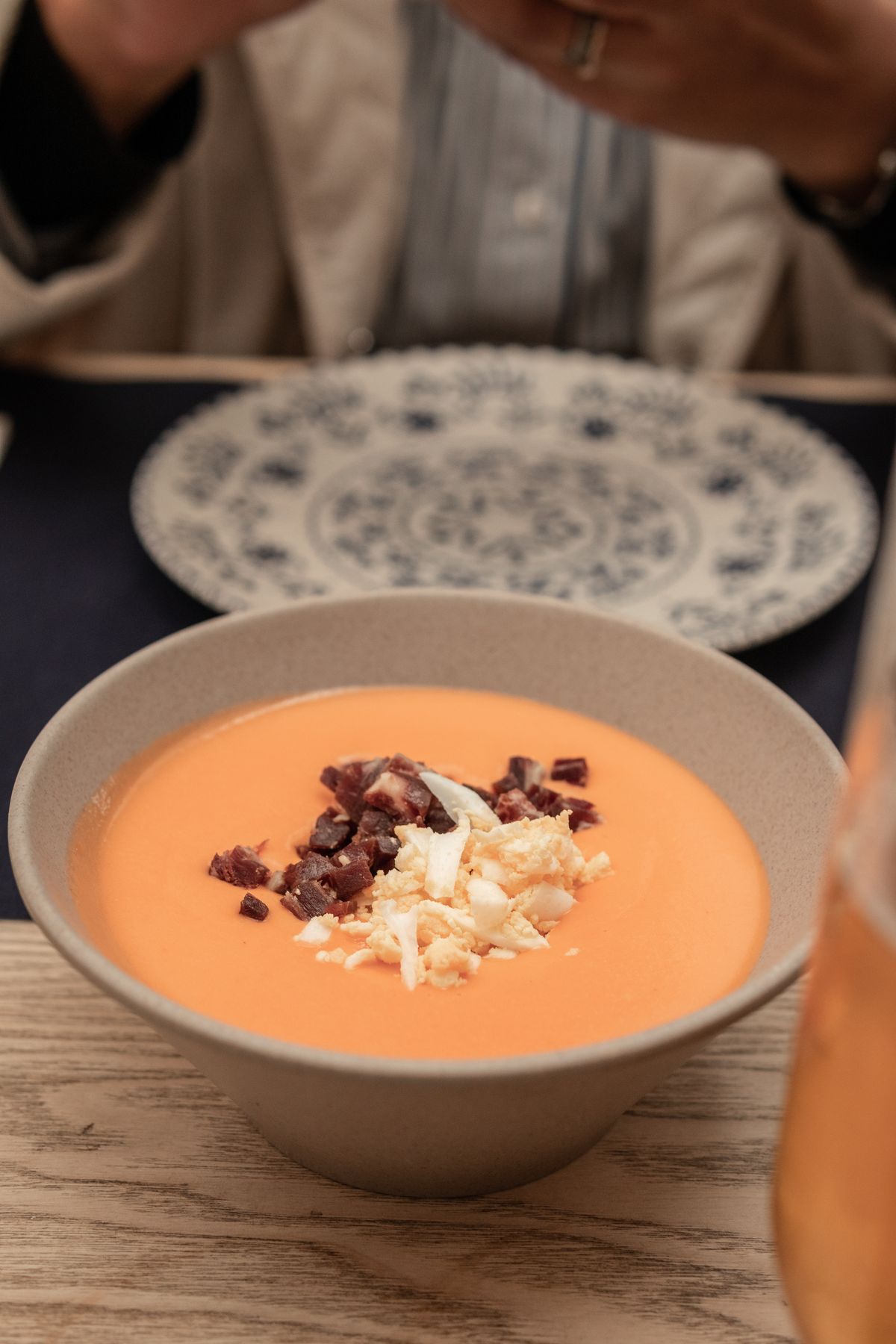 Salmorejo cordobés servido con jamón y huevo duro en un bol de cerámica