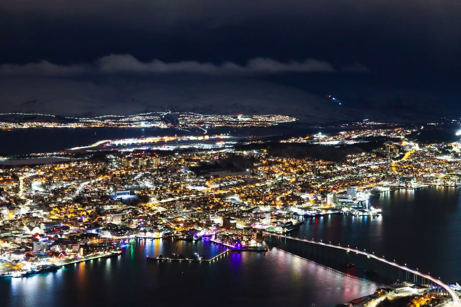 Vista nocturna de Tromsø con las luces de la ciudad junto al agua